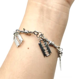 Stacheldraht-Rasierklingen Gothic Armband getragen am Handgelenk, Seitenansicht zeigt gedrehte Kette mit vier Rasierklingen-Anhängern in silberfarbener Zink-Legierung, Alternative Schmuck