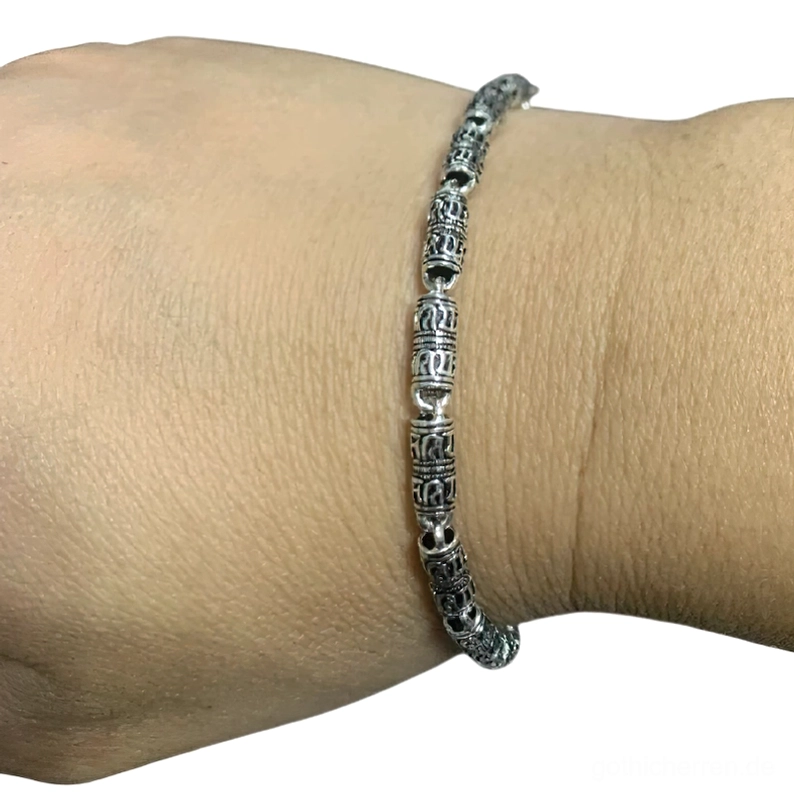 Verwittertes Silber-Armband mit okkulten Symbolen getragen am Handgelenk, nahaufnahme seitenansicht, zeigt antikes Patina-Finish und detaillierte Gravuren, gothic-style armband