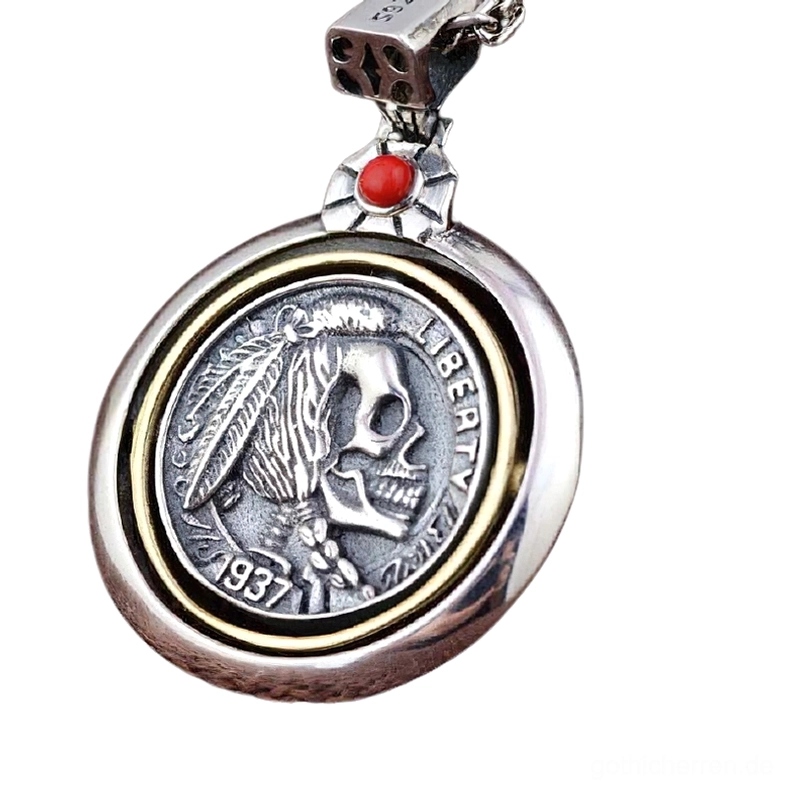 Detailnahaufnahme des gotischen Totenkopf-Anhängers mit Messinginnenbordüre, eingraviertem Federn- und Totenkopf-Muster, rotem Edelstein-Bail und dramatischem Silber-Kontrast auf weißem Hintergrund für Schmuckfotografie
