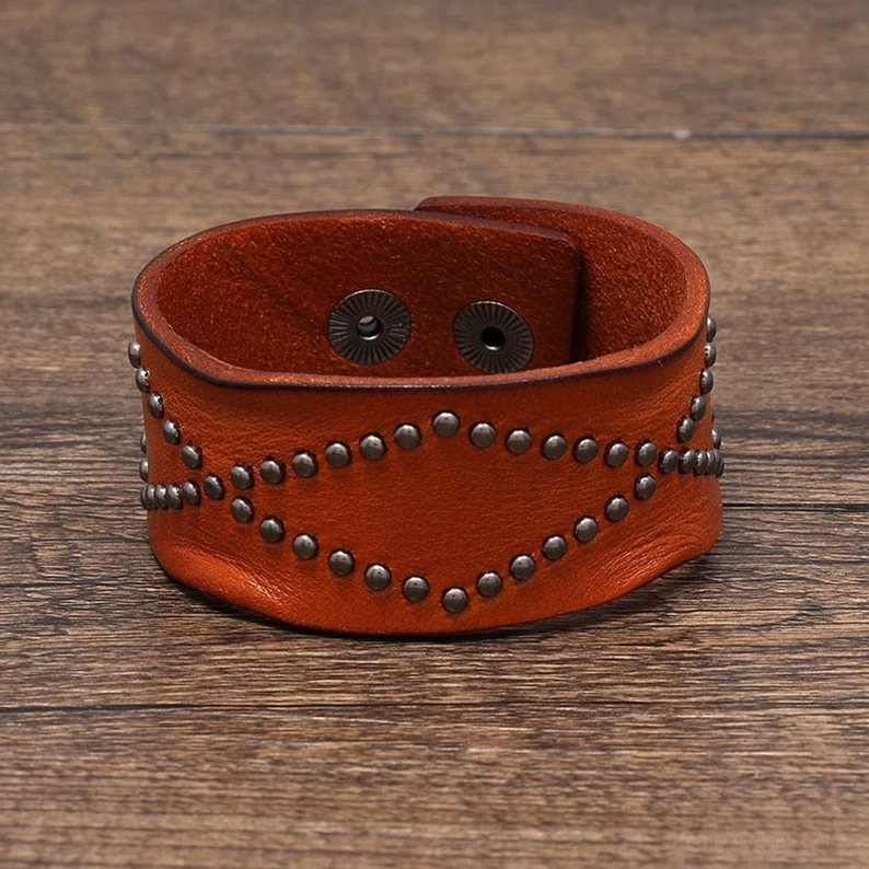 Hellbraun-Ledernes Gothic-Armband von oben flache Ansicht zeigt vollständige Nietgeometrie und Druckknopf-Schnallenverschluss Detail