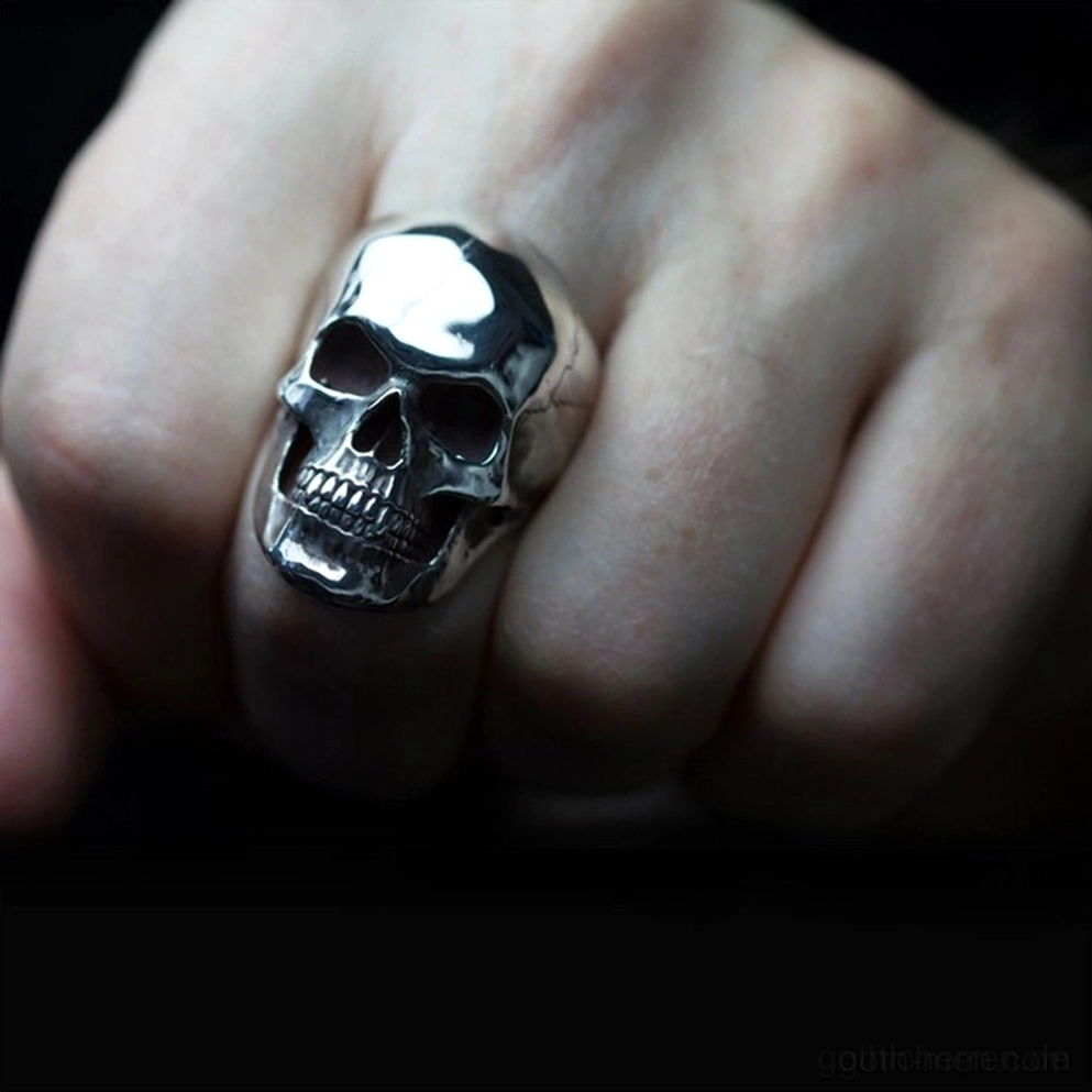 Dunkler Silber Totenkopf-Ring an Hand getragen Nahaufnahme kompaktes gothisches Schmuckdesign poliertes Metallband und Fingerpassform-Demonstration
