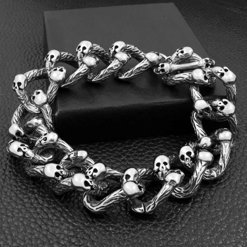 Vintage-Totenkopf-verziertes Kettenarmband Draufsicht auf dunklem Hintergrund dichte Totenkopf-Akzente professionelle Schmuck-Fotografie gotisches Design Antik-Silber