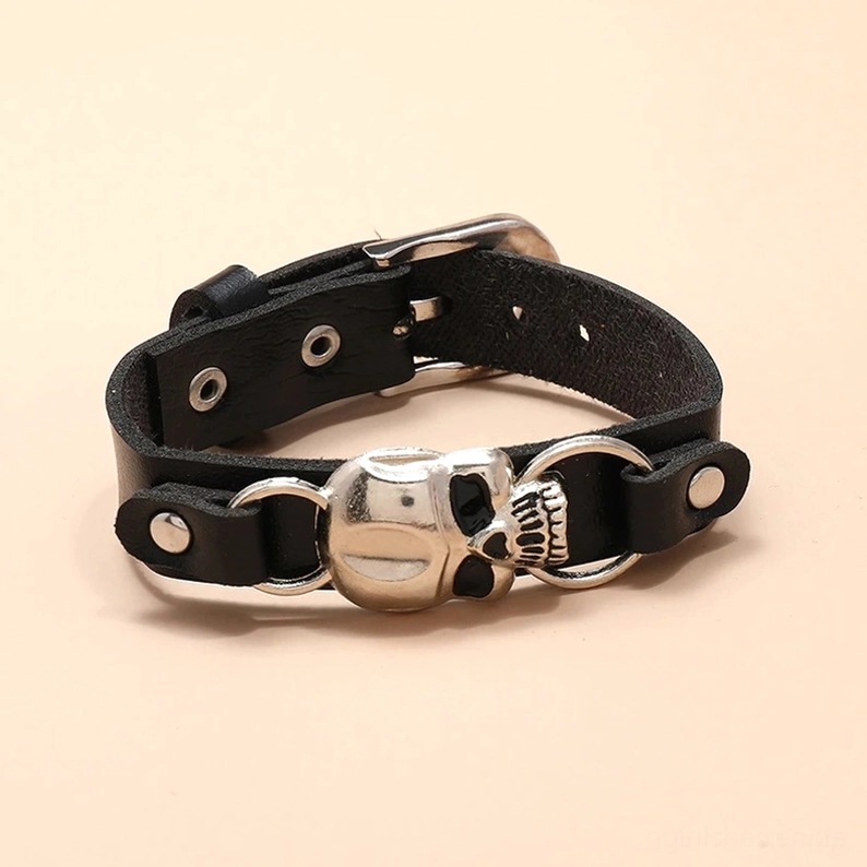 Schwarzes Leder Totenkopf Manschettenarmband Flatlay Draufsicht, bronzefarbene Metalldetails und doppelte D-Ringe sichtbar, Gothic Punk Schmuck Design