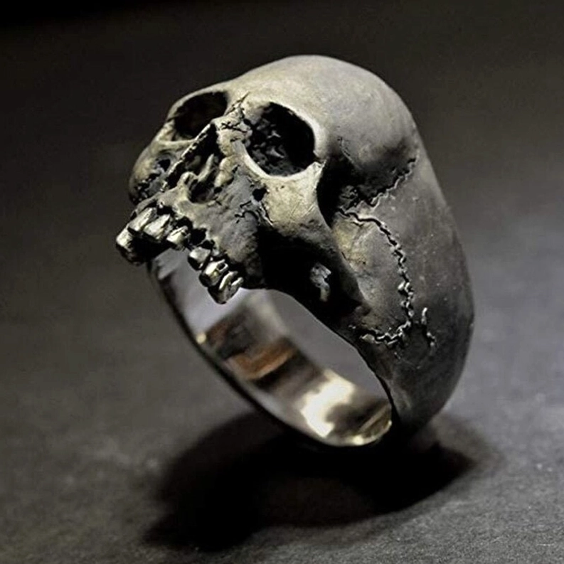 Silber totenkopf ring nahaufnahme zeigt realistische zahndetails und scharfe schnitzarbeiten auf dunklem hintergrund