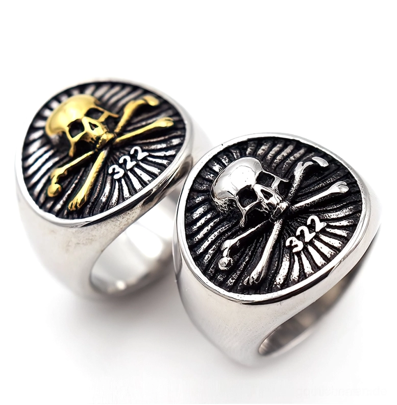 Vergleich: Silberner und goldener Totenkopf Crossbones Sigelring nebeneinander, Aufsicht-Winkelansicht auf weißem Hintergrund