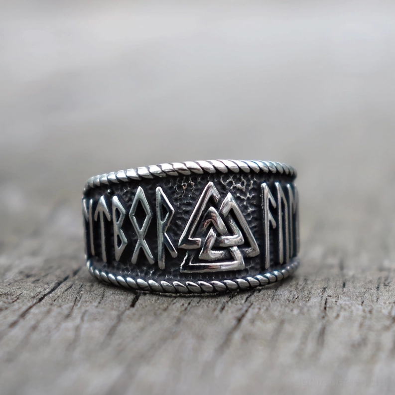 Valknut Edelstahl gothischer Ring Frontansicht auf Holzplanke - verdrehte Seilkante und Runengravierungen Detailansicht
