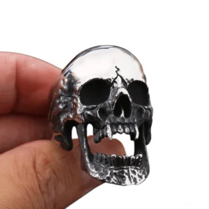 Vampire Skull Ring an menschlichem Finger getragen, Vorderansicht zeigt vintage silbernen Finish mit polierter Schädelkrone des gotischen Rings auf weißem Hintergrund