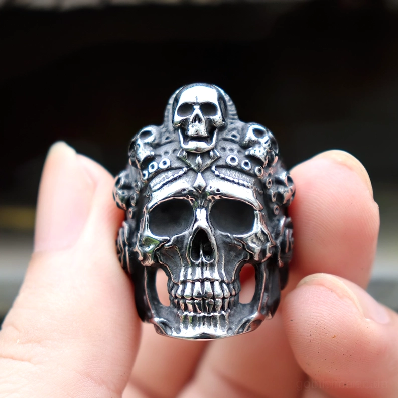Vintage Skull Biker Ring an Menschenfinger getragen zeigt glänzend polierte silberne Edelstahloberfläche mit kühnem Totenkopfdesign
