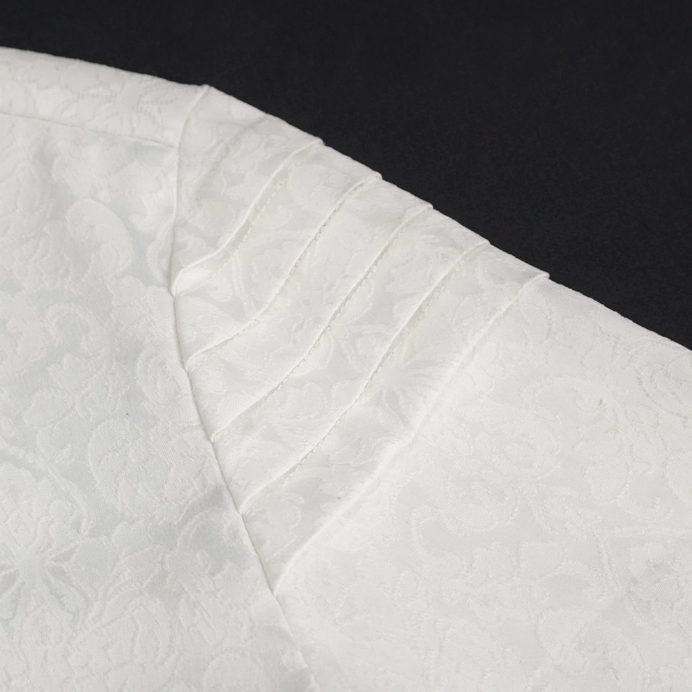 Nahaufnahme weiße gotische Herrenhemd Schulterplissee und Jacquard-Stofftextur mit Paisley-Muster, zeigt Verarbeitungsdetails und Stoffqualität