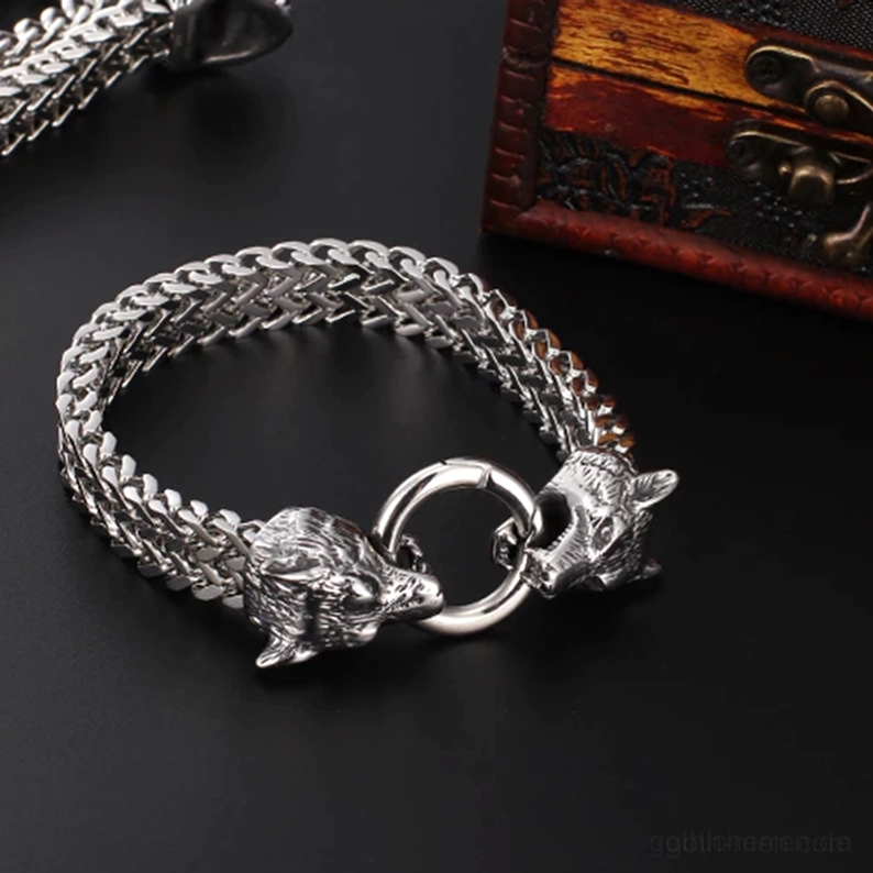 Antik-Silberton Wolfskopf Edelstahl Gothic Armband auf vintage Holzbox, Doppel-Wolfskopf-Federverschluss Detail, rustikale Szene mit dunklem Hintergrund